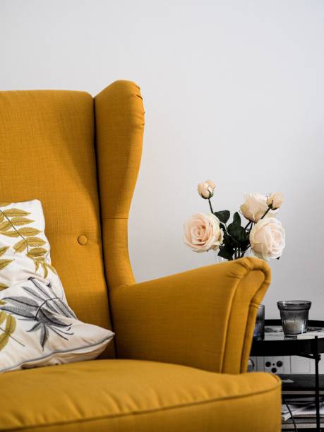 istock Elegant brown couch with a vase of white roses on a table 1445367352