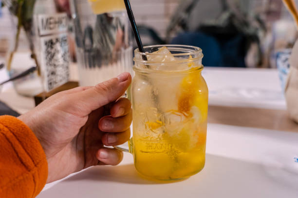 istock Man's hand holding cocktail at restaurant 1445367444