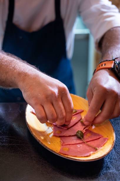 istock Vertical shot of the chef serving ham on a yellow plate 1445368429