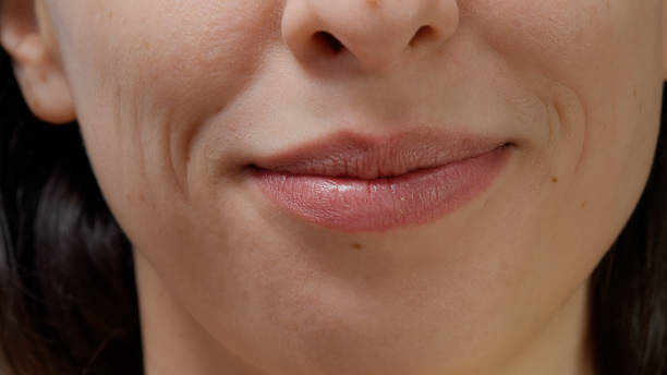 istock Macro shot of female model smiling and moving lips on camera 1445372936