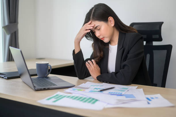 istock Stressed young business woman working on laptop with documents in modern office, workload concept 1445374364