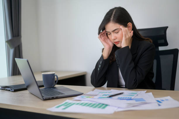 istock Stressed young business woman working on laptop with documents in modern office, workload concept 1445374454