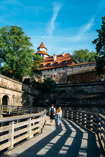 People walking to an old medieval tower in Nuremberg, Bavaria, Germany
