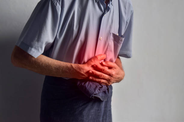istock Asian man suffering from upper abdominal pain. It can be caused by stomach ache, enteritis, colitis, appendicitis, hepatitis, pancreatitis, food poisoning, etc. 1445377390