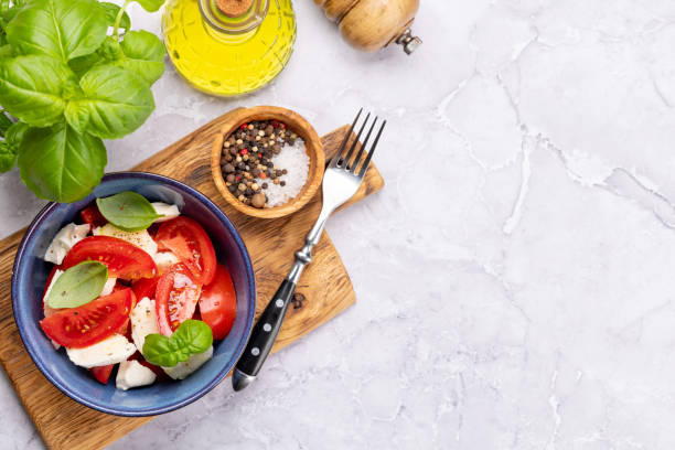 istock Caprese salad with ripe tomatoes, mozzarella cheese and garden basil 1445378780