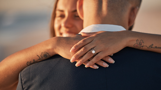 Wedding, love and couple hug with ring, happiness and celebration for life partnership, bond and union at ceremony event. Happy, diamond wedding ring and hands of woman, girl or partner embrace man