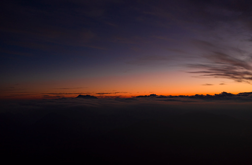 The sun sets in the city and then the sky in blue and orange colors appears.