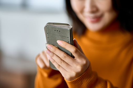 Una mujer usando un teléfono inteligente con una sonrisa photo