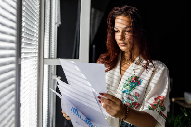 istock Diligent young woman reviewing paperwork by the window 1445381241