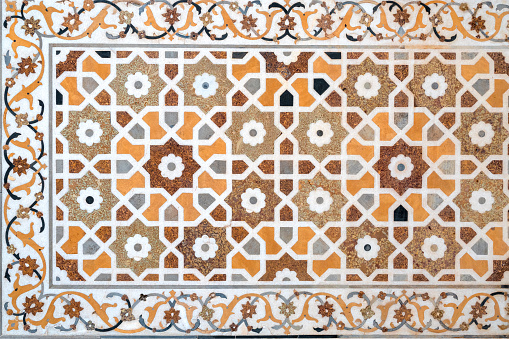 Close-up of details of a marble wall with floral patterns and oriental mosaic on surface of Taj Mahal tomb in Agra, India