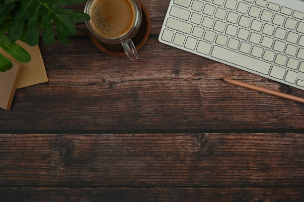istock Flat lay wireless keyboard, coffee cup, sticky notes and potted plant on wooden table. Top view with copy space. 1445382066