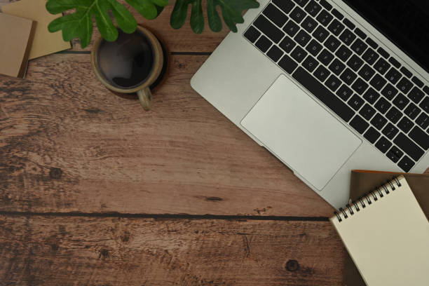 istock Hipster working desk with laptop computer, notepad, coffee cup and potted plant. Top view, flat lay with copy space. 1445382086