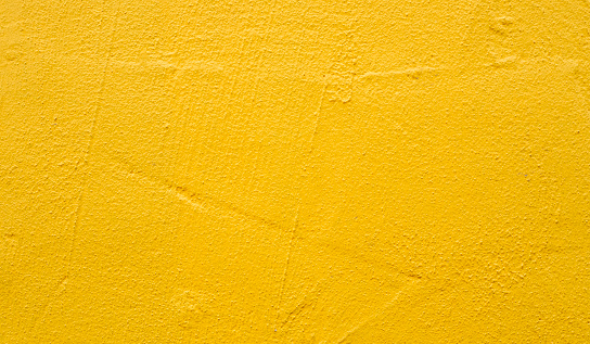 Rough blank wall painted by bright yellow paint as texture background or backdrop