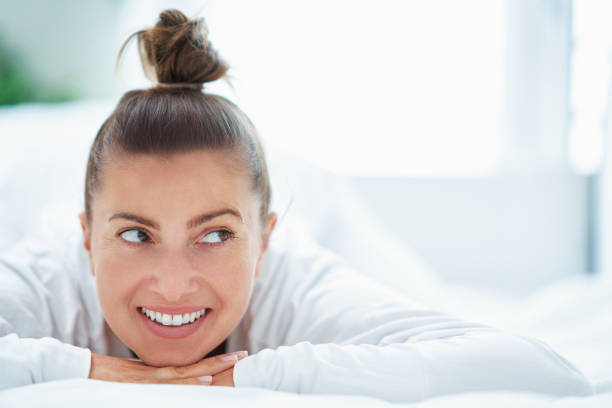 Woman posing smiling at camera while sunbathing on the beach