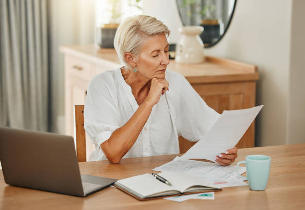 Senior woman, debt and laptop bills payment for loan budget and retirement finance paperwork at home. Retired Ukraine elderly person reading pension, loan and mortgage savings financial bank report pago de facturas de mujeres mayores, deudas y computadoras portátiles para el presupuesto del préstamo y el papeleo de finanzas de jubilación en el hogar. jubilado de ucrania persona mayor leyendo pensiones, préstamos y ahorros hipotecarios informe del