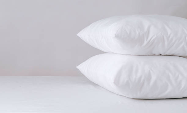two comfortable pillows, white bed linen, no one there. Bed linen, home comfort, free space. Good morning in daylight