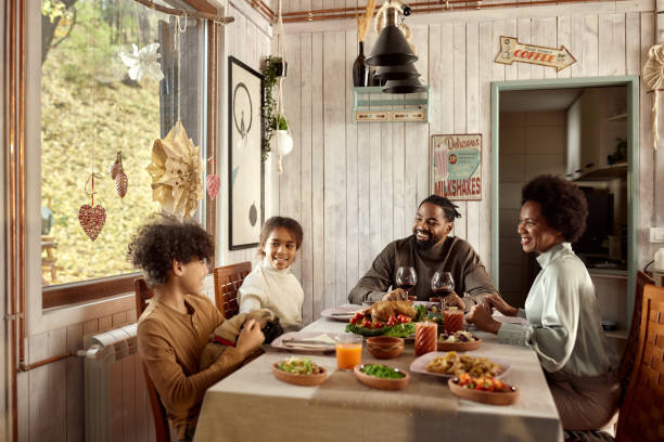 istock Happy black family talking during lunch at dining table. 1445386702