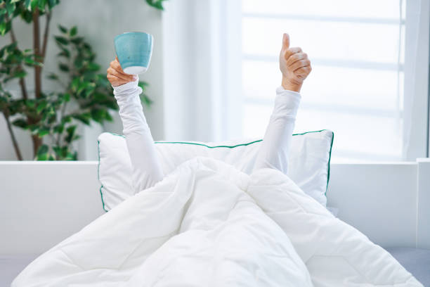 istock Young nice woman in bed with coffee or tea mug 1445386705