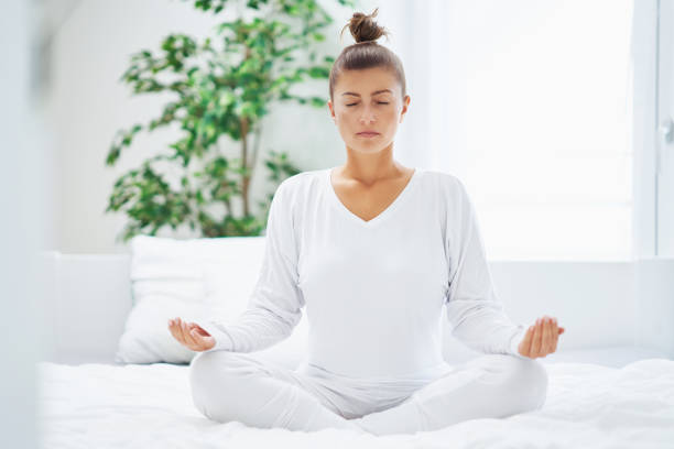istock Nice female in bed relaxing or doing yoga 1445387646
