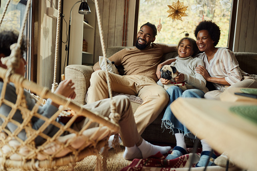 Happy African American family communicating while spending their time together in the living room.