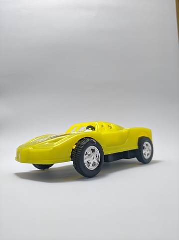 Close up view of yellow racing car toy isolated on white background.