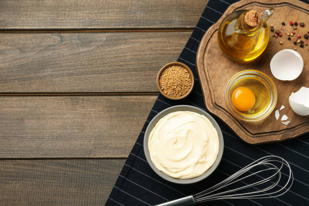 istock Bowl with fresh mayonnaise and ingredients on wooden table, top view. Space for text 1445390047