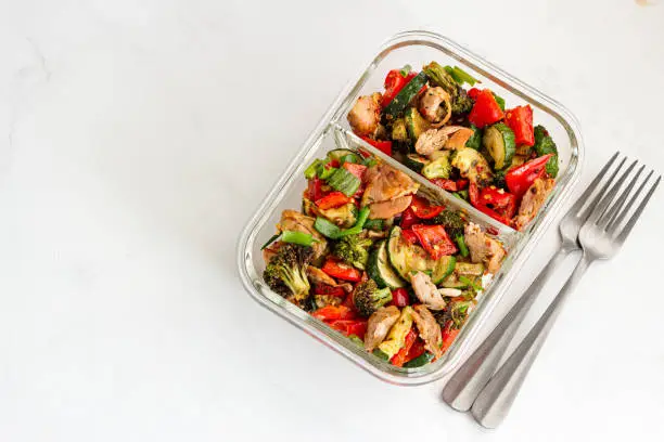 Healthy Vegetable Chicken Salad in a Lunch Box on White Background Top Down Photo