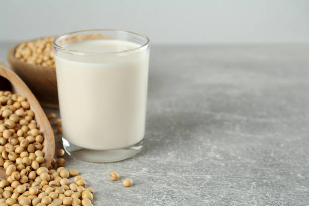 istock Glass with fresh soy milk and grains on grey table. Space for text 1445391450