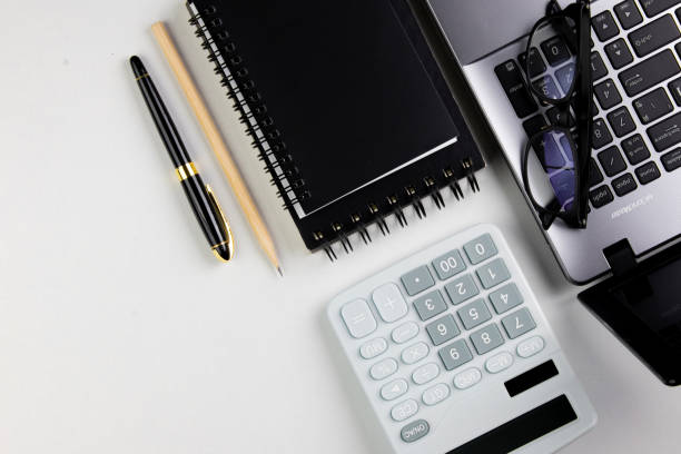 istock top view of modern white office desk with computer keyboard, blank notebook page and other equipment on white background. 1445392483