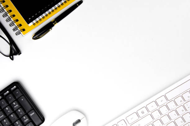 istock top view of modern white office desk with computer keyboard, blank notebook page and other equipment on white background. 1445392499