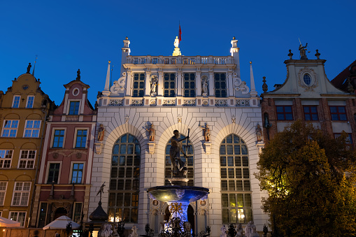 The Artus Court and the Neptune Fountain at night in city of Gdansk in Poland.