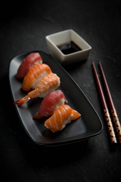 istock sushi with chopstick over black stone 1445392827