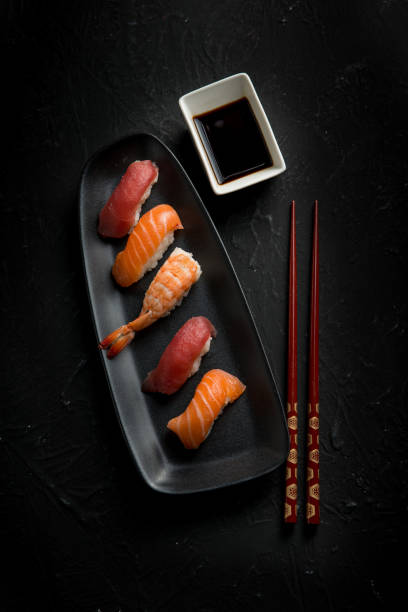 istock sushi with chopstick over black stone 1445392840