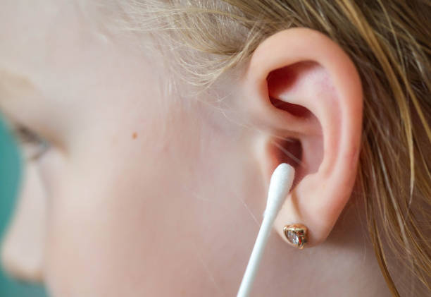 чистка ушей 5-летнего ребенка от серы ватными тампонами, крупным планом. гигиеническая процедура. - ear canal стоковые фото и изображения