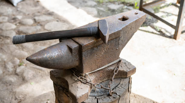 istock Anvil in the forge and a lot of hammers. Workshop for working with iron. industry 1445392931