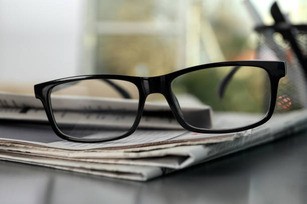 istock Stack of newspapers and glasses on grey table indoors, closeup 1445392995