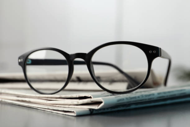 istock Stack of newspapers and glasses on grey table indoors, closeup 1445393030