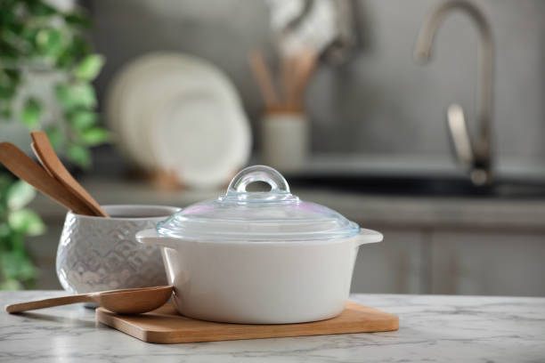 istock Ceramic pots and cooking utensils on white marble table in kitchen 1445393191