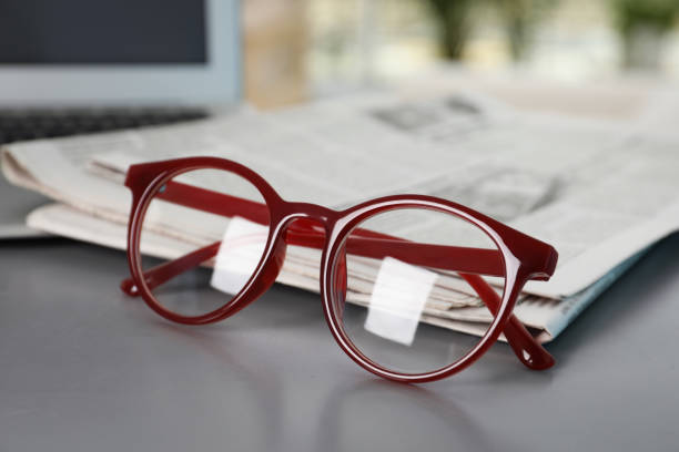 istock Newspapers and glasses on grey table, closeup 1445393481