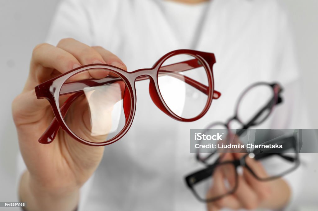 Woman with different glasses on light background, closeup Eyeglasses Stock Photo