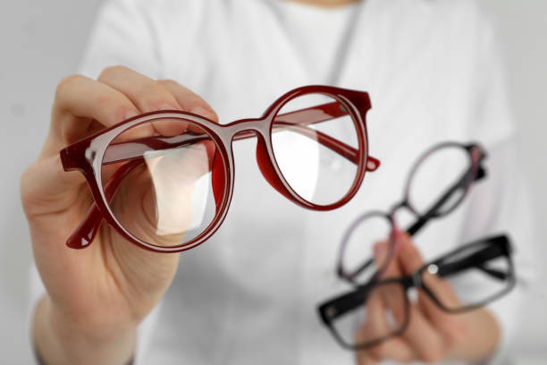 Woman with different glasses on light background, closeup stock photo