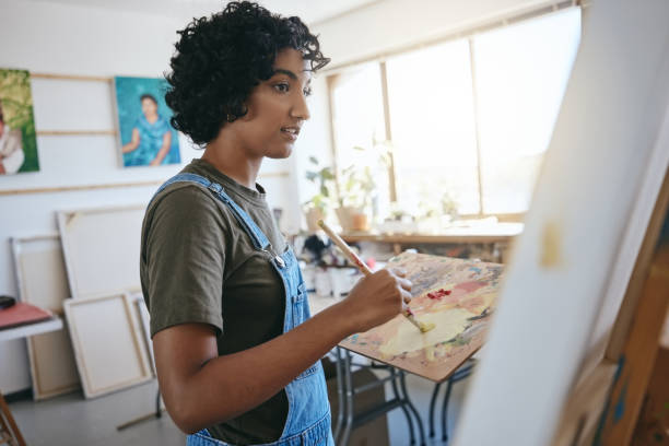istock Paint, art and creative with a woman painter or artist working on a canvas in her workshop or studio. Artistic, creativity and artwork with a young female painting as a form or arts and crafts 1445394367