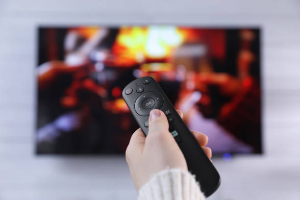istock Woman with remote control watching TV at home, closeup 1445394893