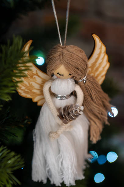 istock Christmas tree decoration, white angel with bokeh on green tree 1445396171