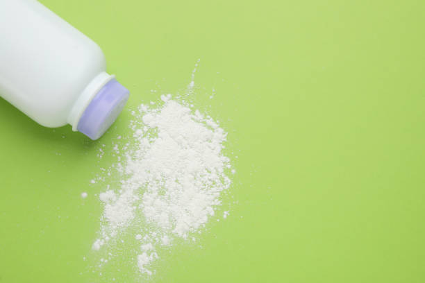 istock Bottle and scattered dusting powder on light green background, top view with space for text. Baby cosmetic product 1445396309