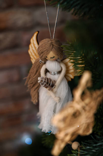 istock Christmas tree decoration, white angel with bokeh on green tree 1445396433