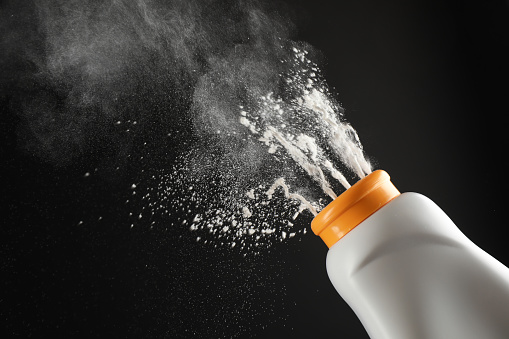 Scattering of dusting powder on black background