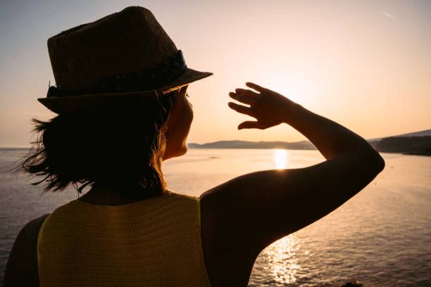 istock Young Woman Blocking The Sun With Her Hand On The Beach 1445396823