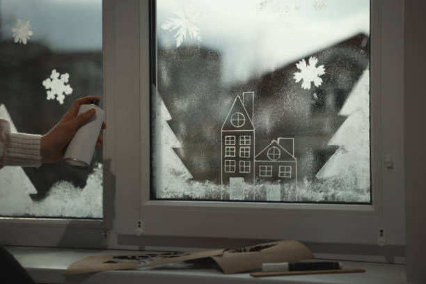 istock Woman using snow spray for decorating window at home, closeup 1445396839
