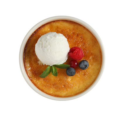 Delicious creme brulee with scoop of ice cream, fresh berries and mint isolated on white, top view